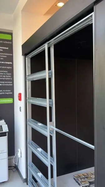 Sötét üzletberendezés üveges tolóajtókkal